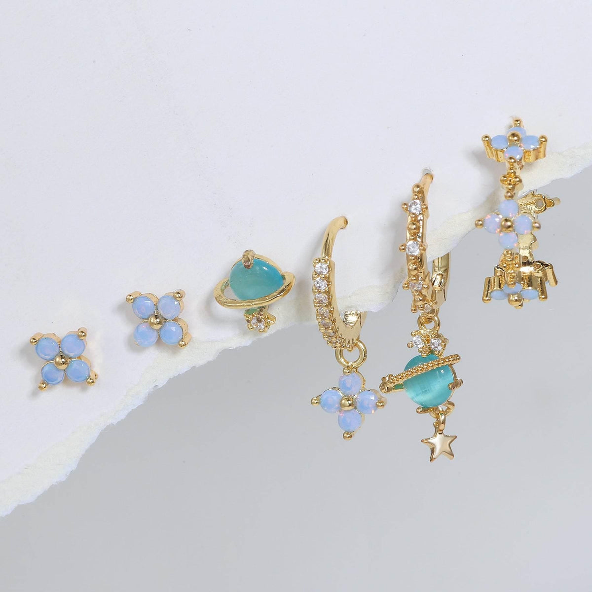 Blue flower and teal drop stacking earrings with gold-tone star and ring details
