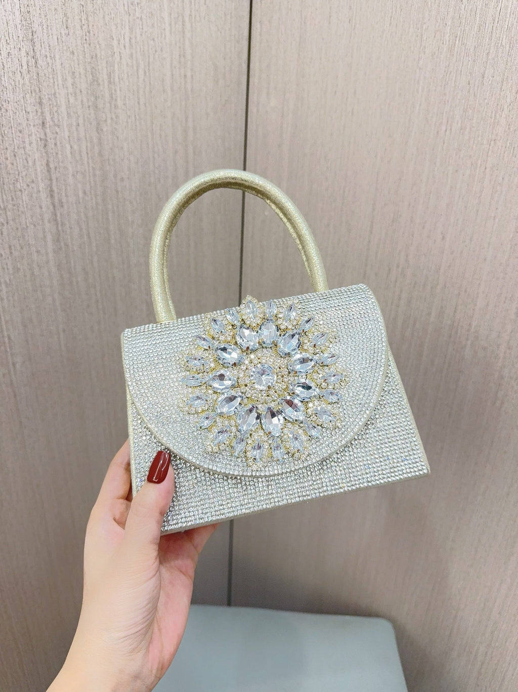 Gold rhinestone clutch purse with curved top handle and jeweled front flap