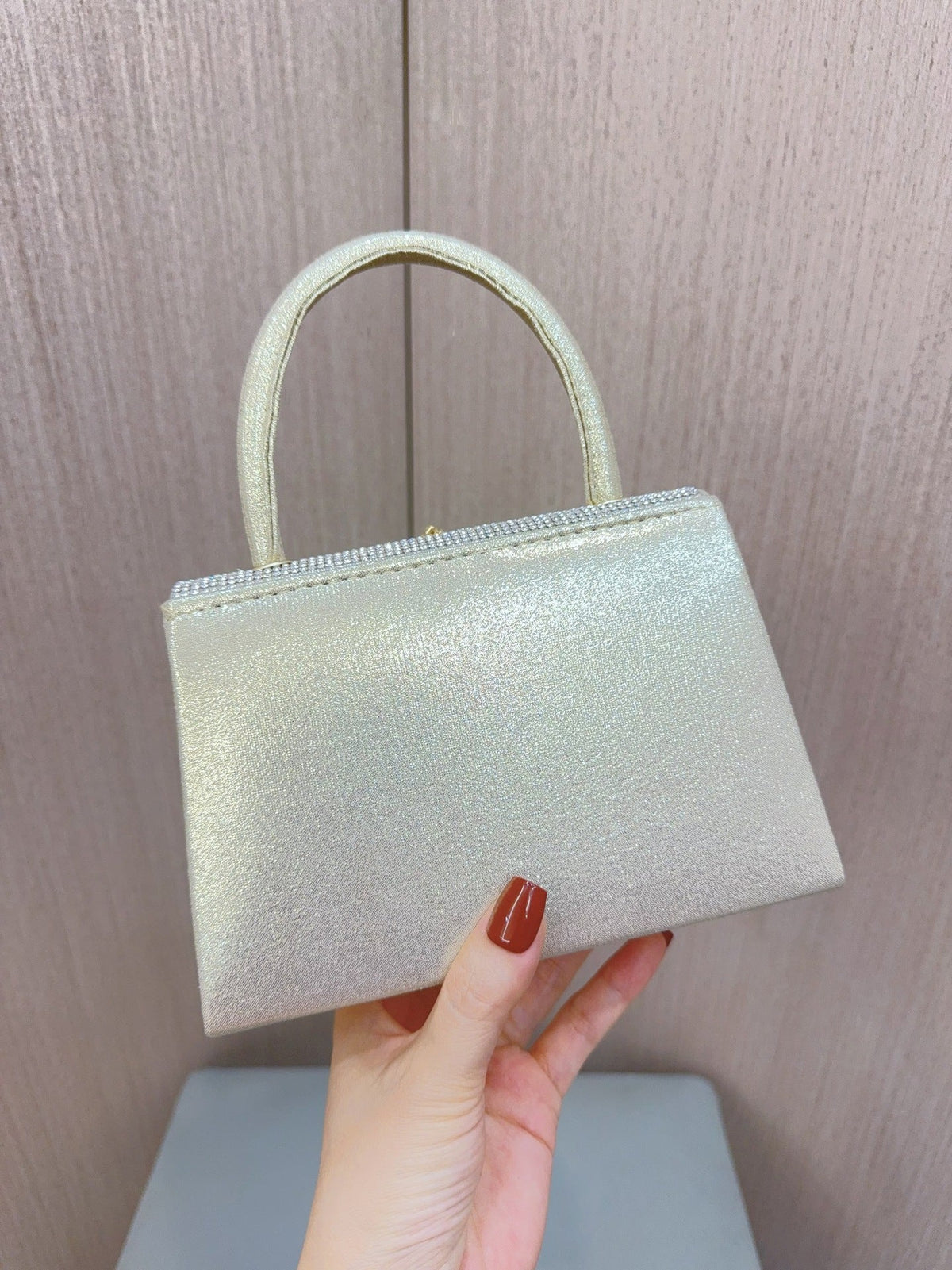 Gold glitter clutch purse with curved handle and smooth front panel, no jewelry