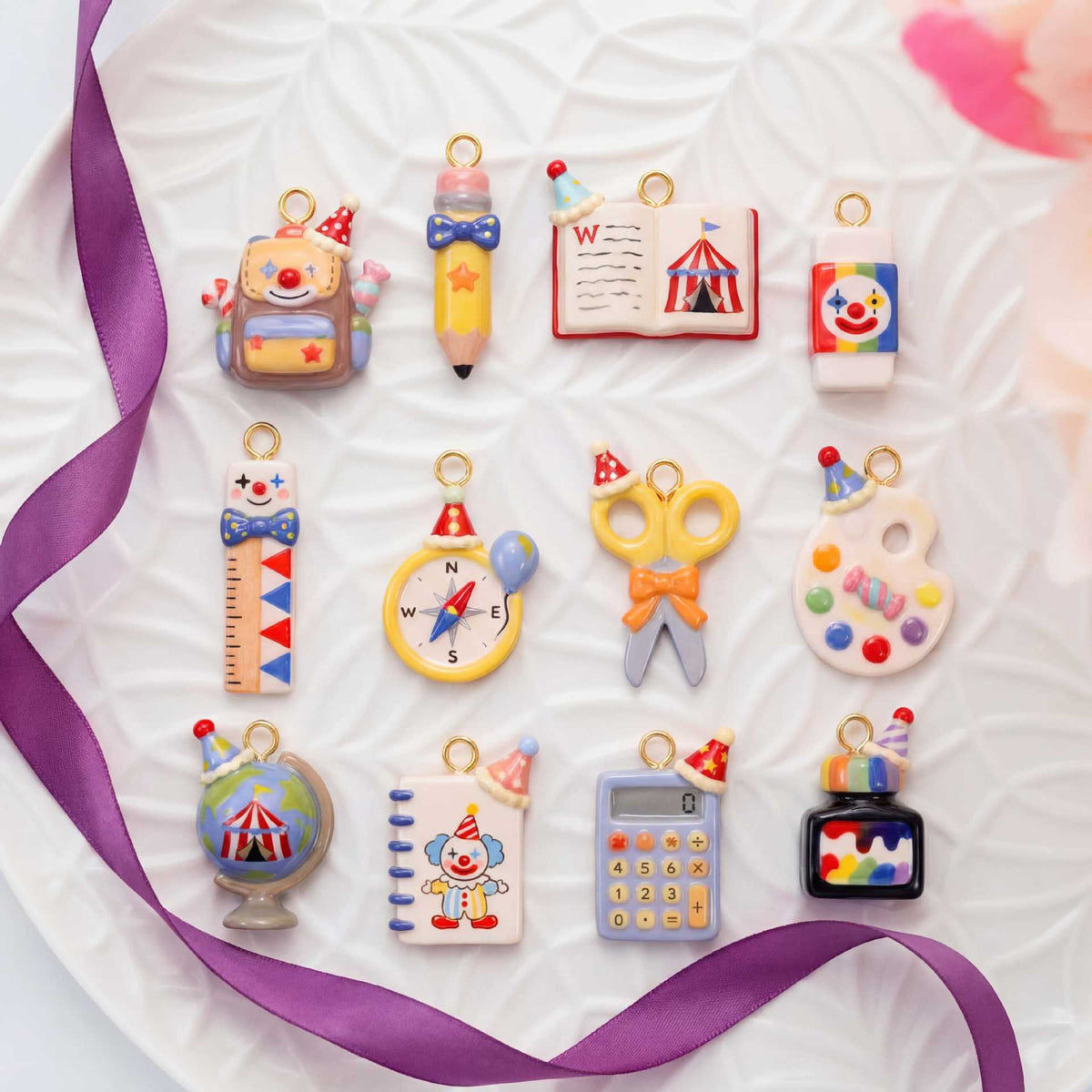Assorted miniature school-supply keychain charms with gold rings on a flat display