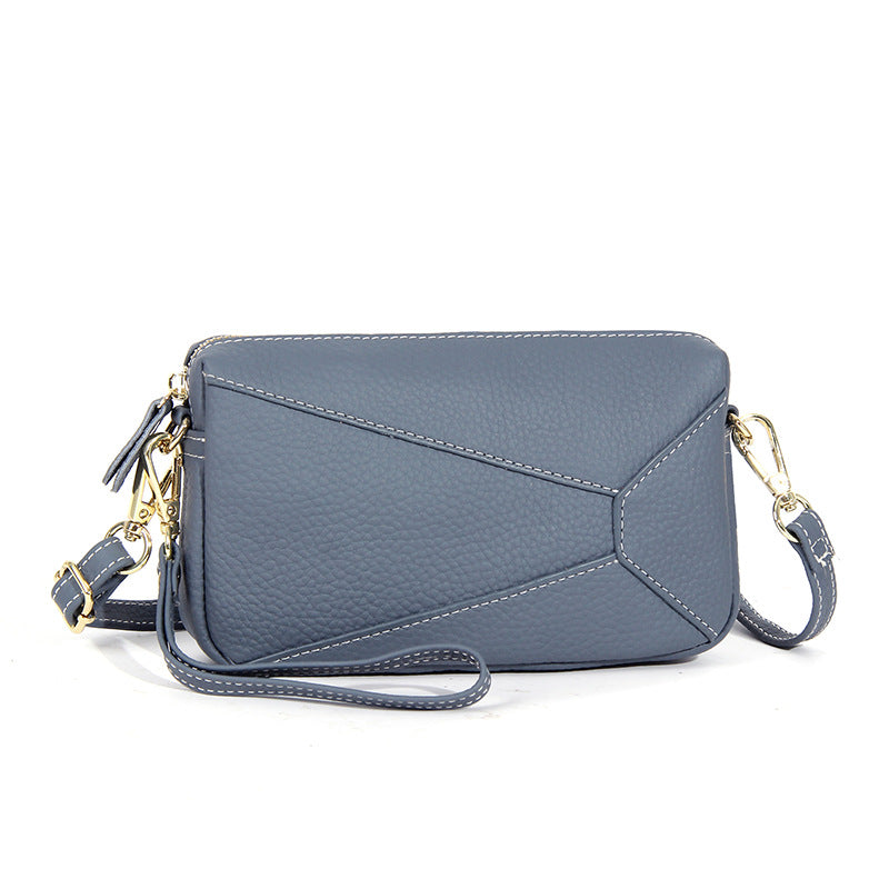 Light gray leather wristlet crossbody bag with zip top and crossbody strap