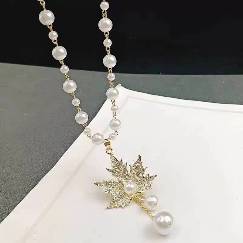 Long pearl beaded necklace with gold starflower pendant and dangling pearls