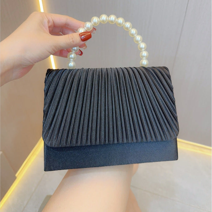 Dark pleated evening clutch with faux pearl handle, handheld style