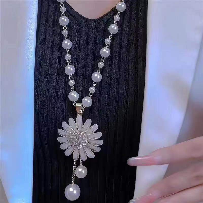 Long pearl necklace with large white daisy flower pendant and dangling pearl drops