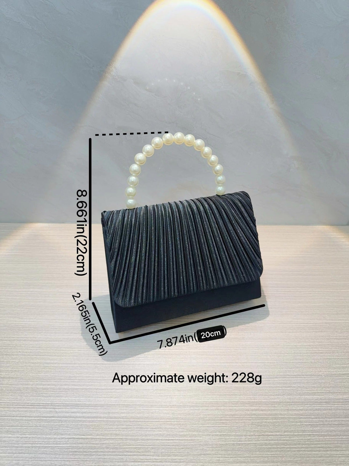 Dark pleated handbag with faux pearl handle and fold-over top flap