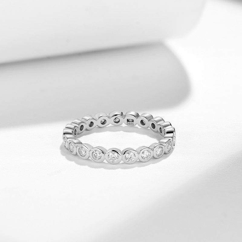Sterling silver band ring set with round clear stones and scalloped links