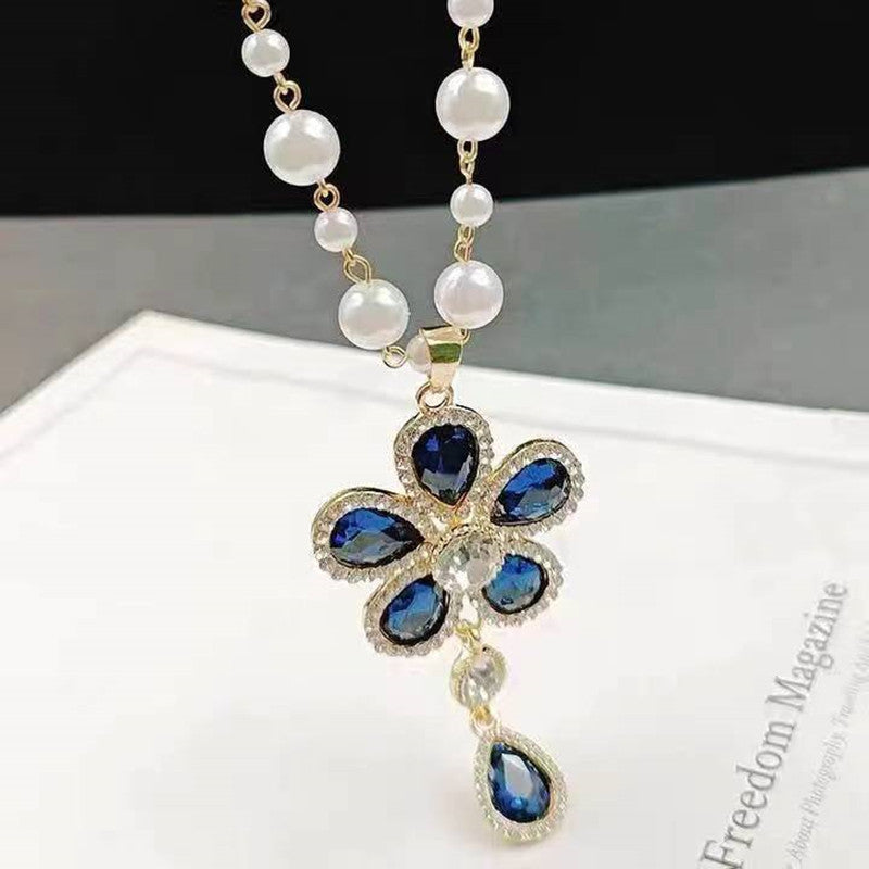 Long pearl necklace with blue flower cross pendant on gold chain