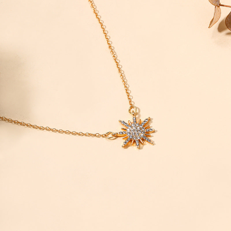 Gold-tone sunburst pendant choker necklace with crystal-like stones
