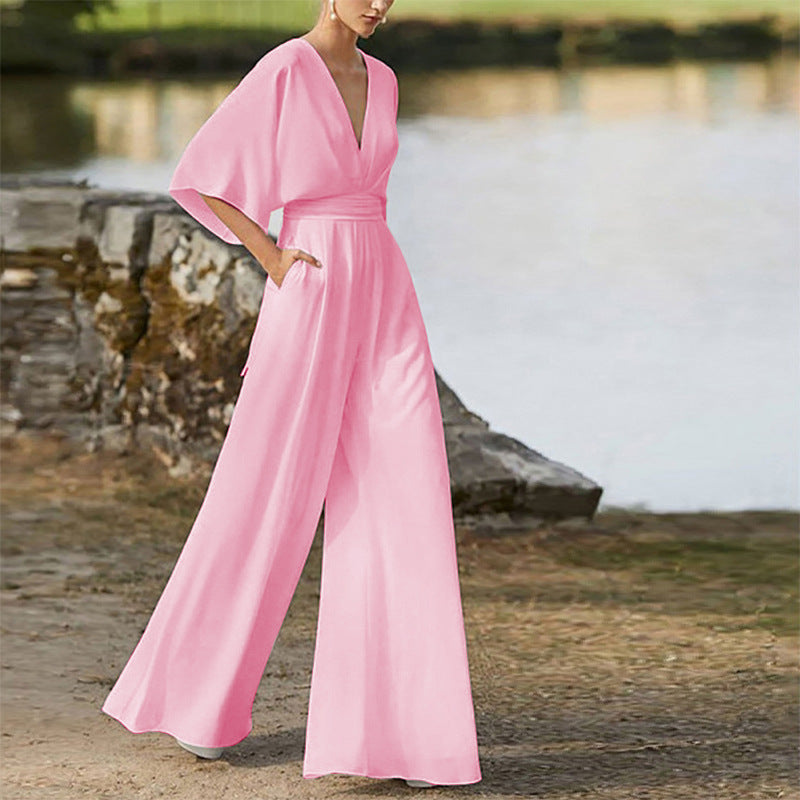 Pink deep V-neck wide-leg jumpsuit with flutter sleeves and belted waist