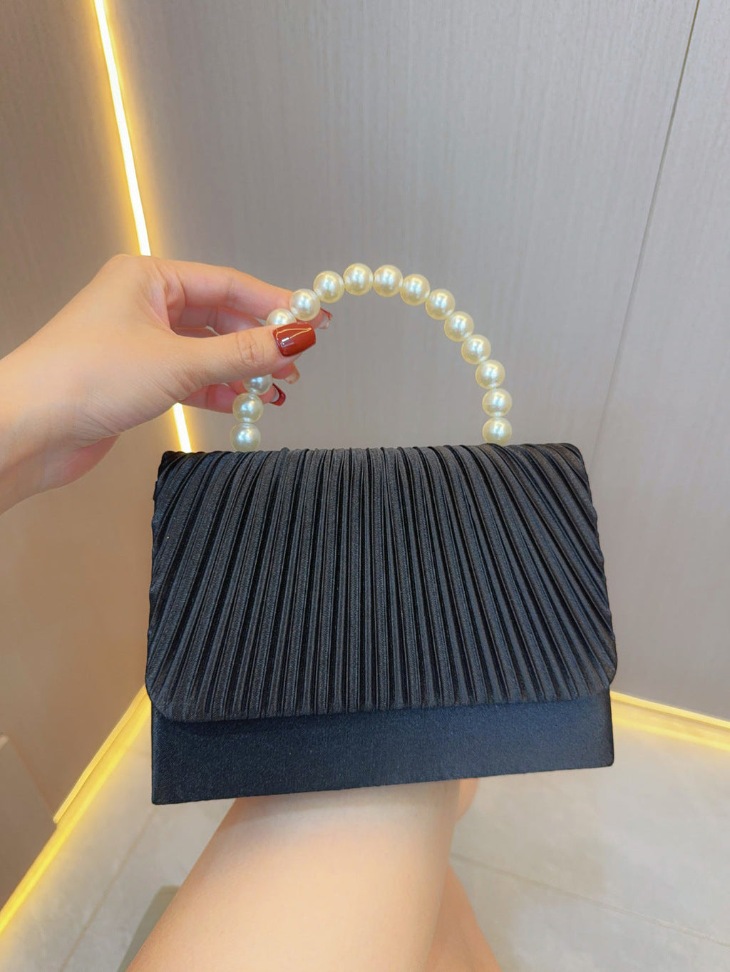 Dark pleated evening clutch bag with faux pearl handle and top flap