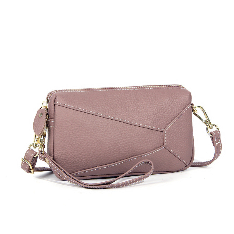Purple leather wristlet crossbody bag with zip top and short shoulder strap
