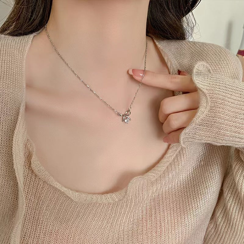 Silver-tone butterfly pendant necklace worn on a knit sweater