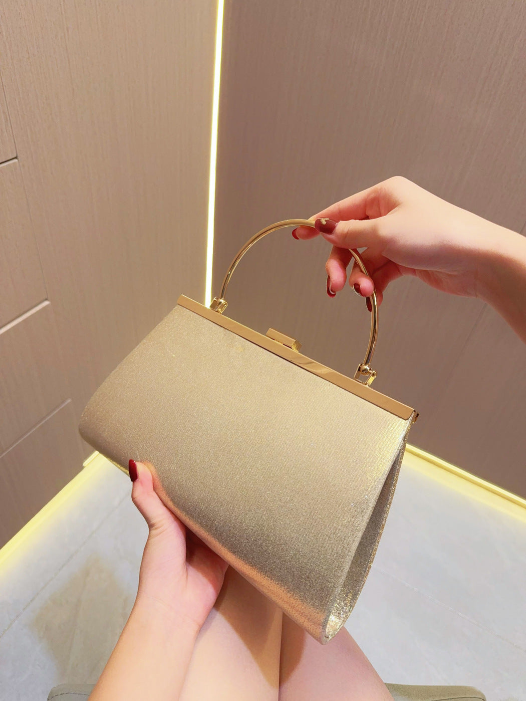 Gold fabric evening clutch with top handle and metal frame clasp