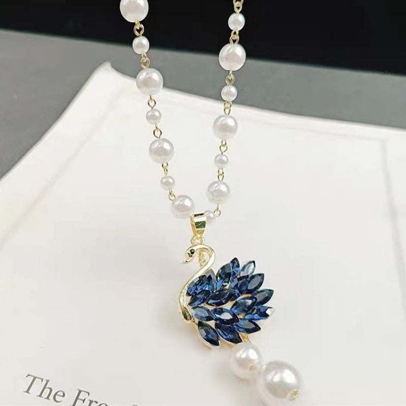 Long pearl necklace with blue leaf drop charm and gold connector
