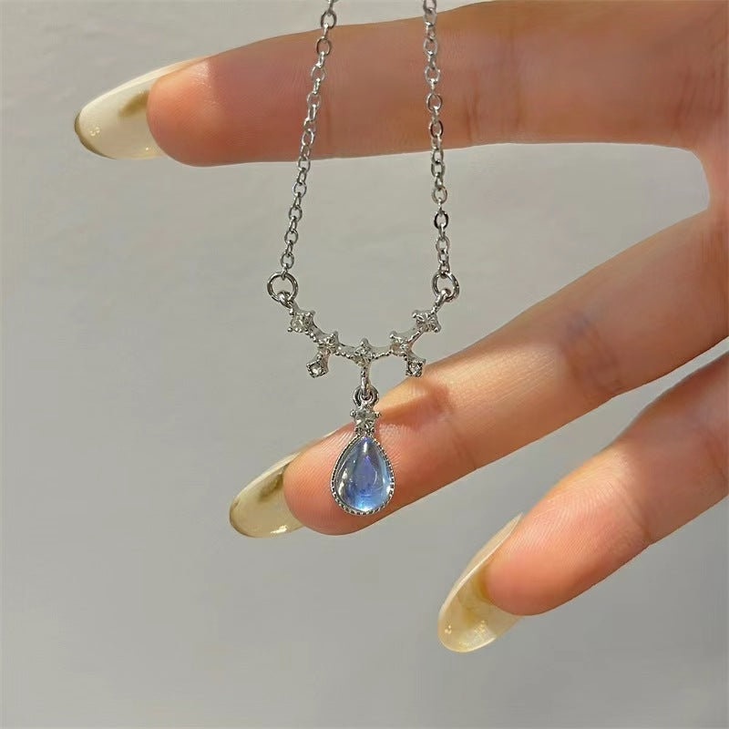 Silver-tone chain necklace with blue teardrop pendant and star charms