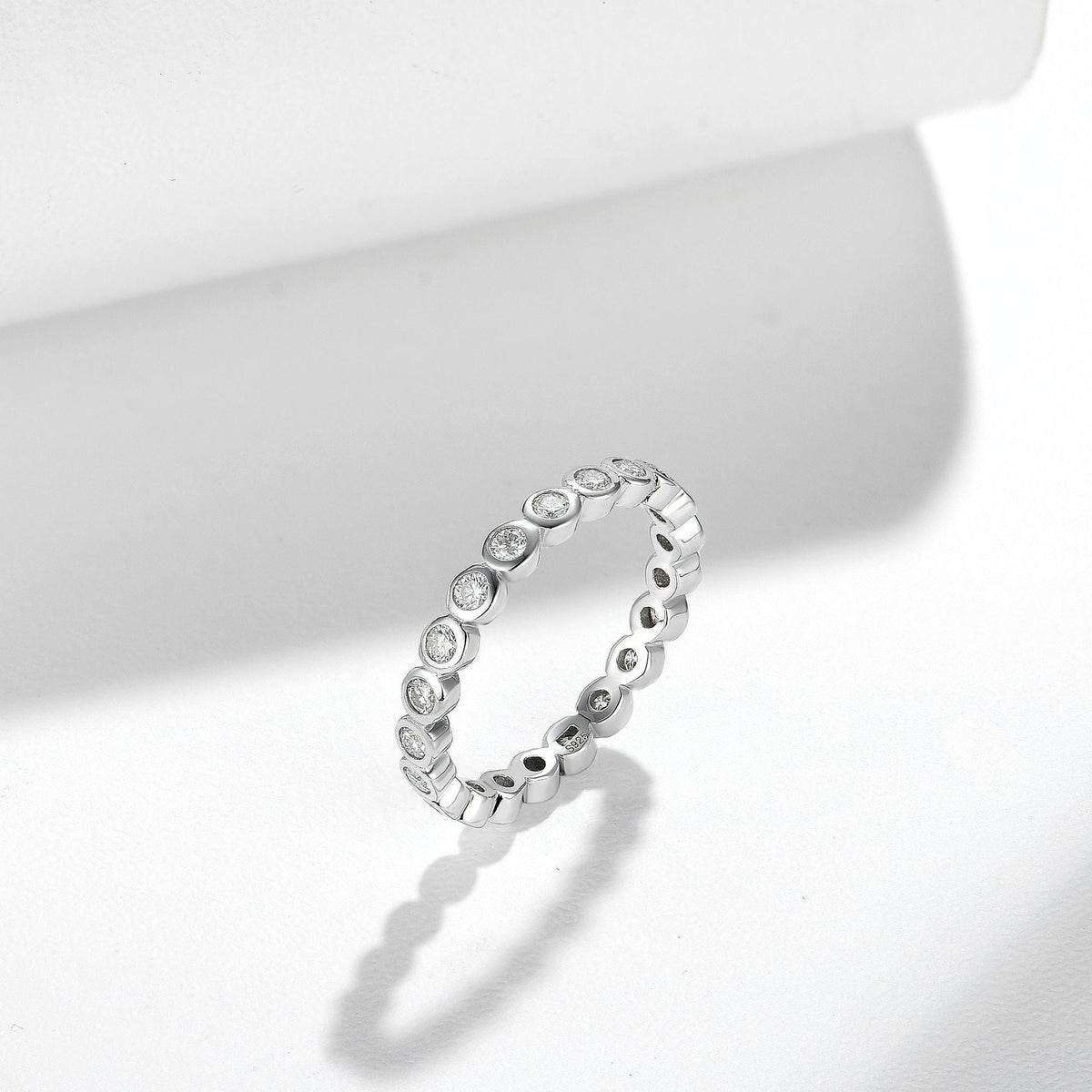 Stackable sterling silver ring set with round clear stones in a linked band