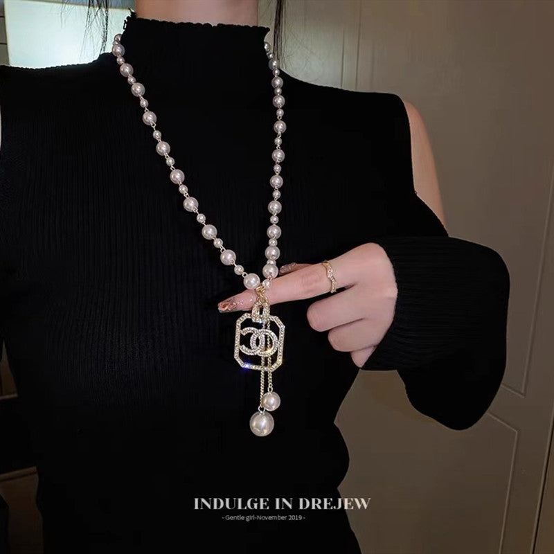 Long pearl bead necklace with heart-and-lock charm pendant