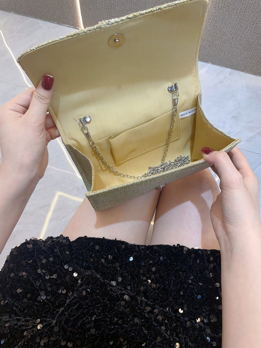 Gold satin-lined clutch handbag interior with clasp and chain handle