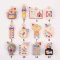 Set of 12 miniature school-supply keychain charms with gold rings, labeled 1–12