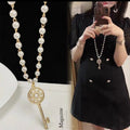 Pearl long necklace with circular keyhole pendant and gold key clasp
