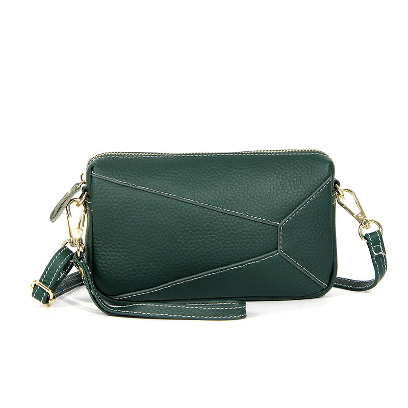 Dark green leather wristlet crossbody bag with zip top and shoulder strap