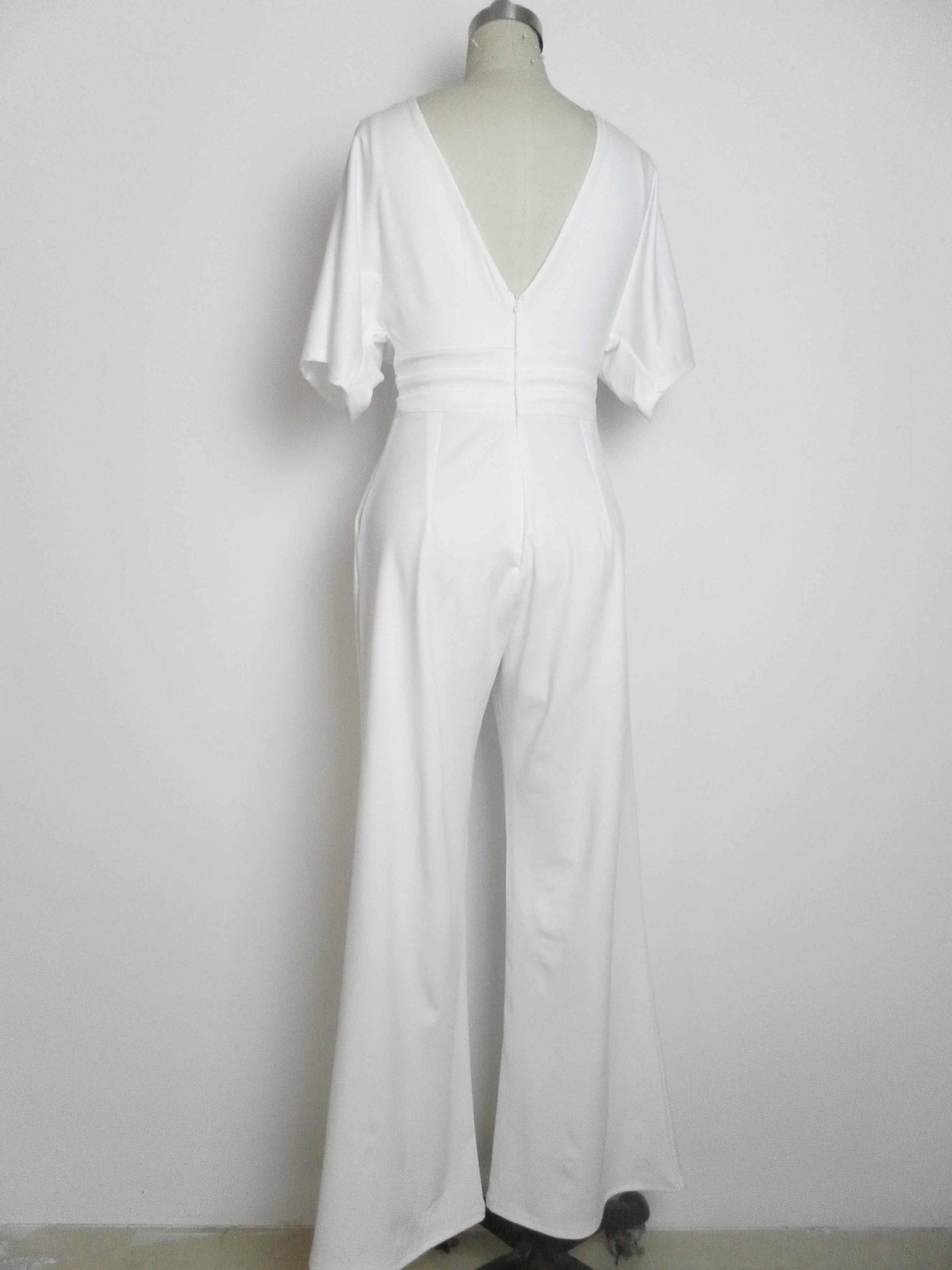White deep V-neck wide-leg jumpsuit with waist tie and flowing wide trousers