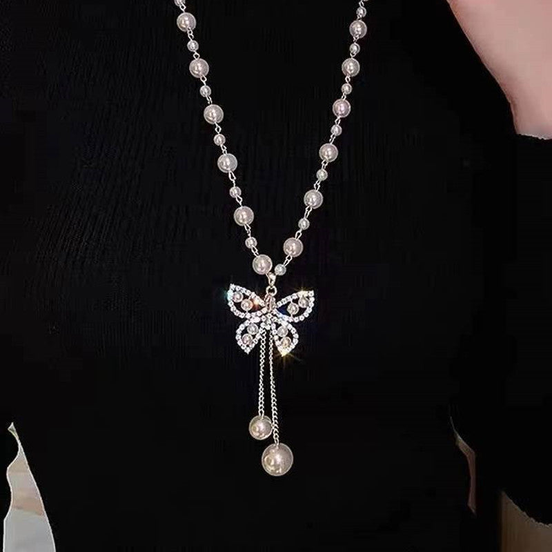 Long pearl necklace with rhinestone bow pendant and dangling pearl tassel