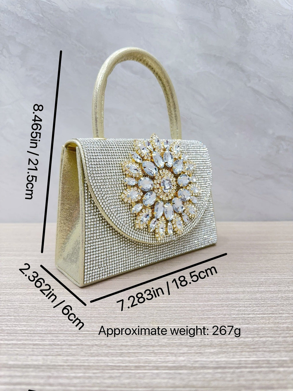 Gold rhinestone evening clutch with ornate crystal front medallion and top loop handle
