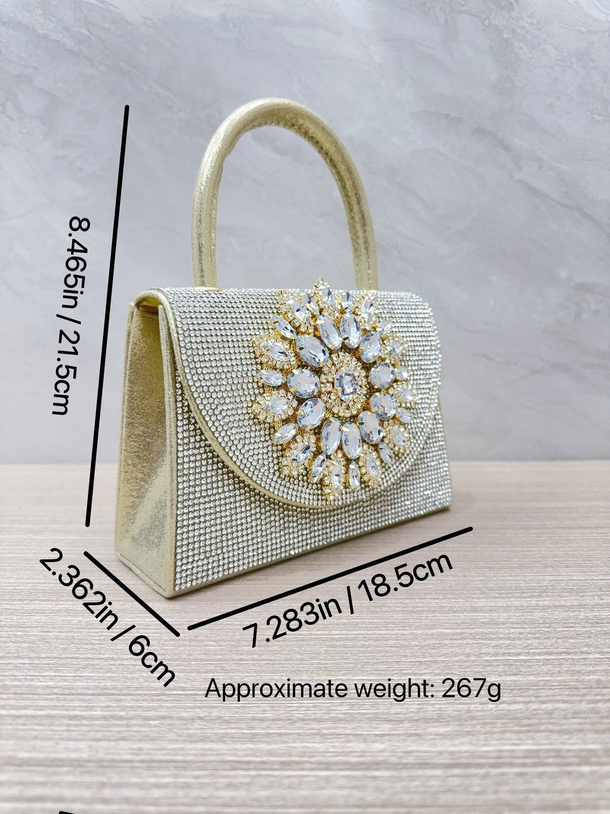 Gold rhinestone evening clutch with ornate crystal front medallion and top loop handle