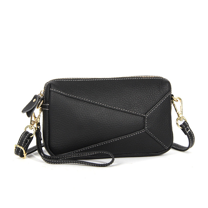 Black leather wristlet crossbody bag with front panel detail and zip top