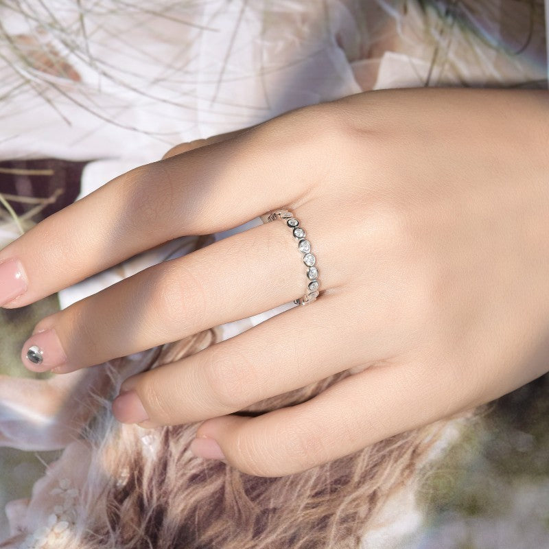 Sterling silver stackable ring set with small round clear stones on hand