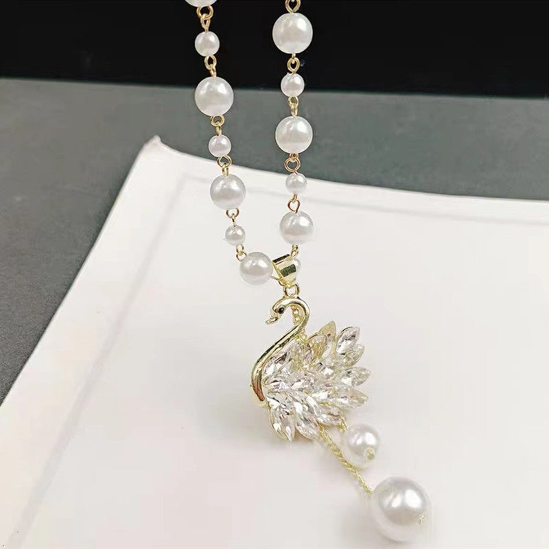Long pearl necklace with crystal leaf pendant and gold clasp