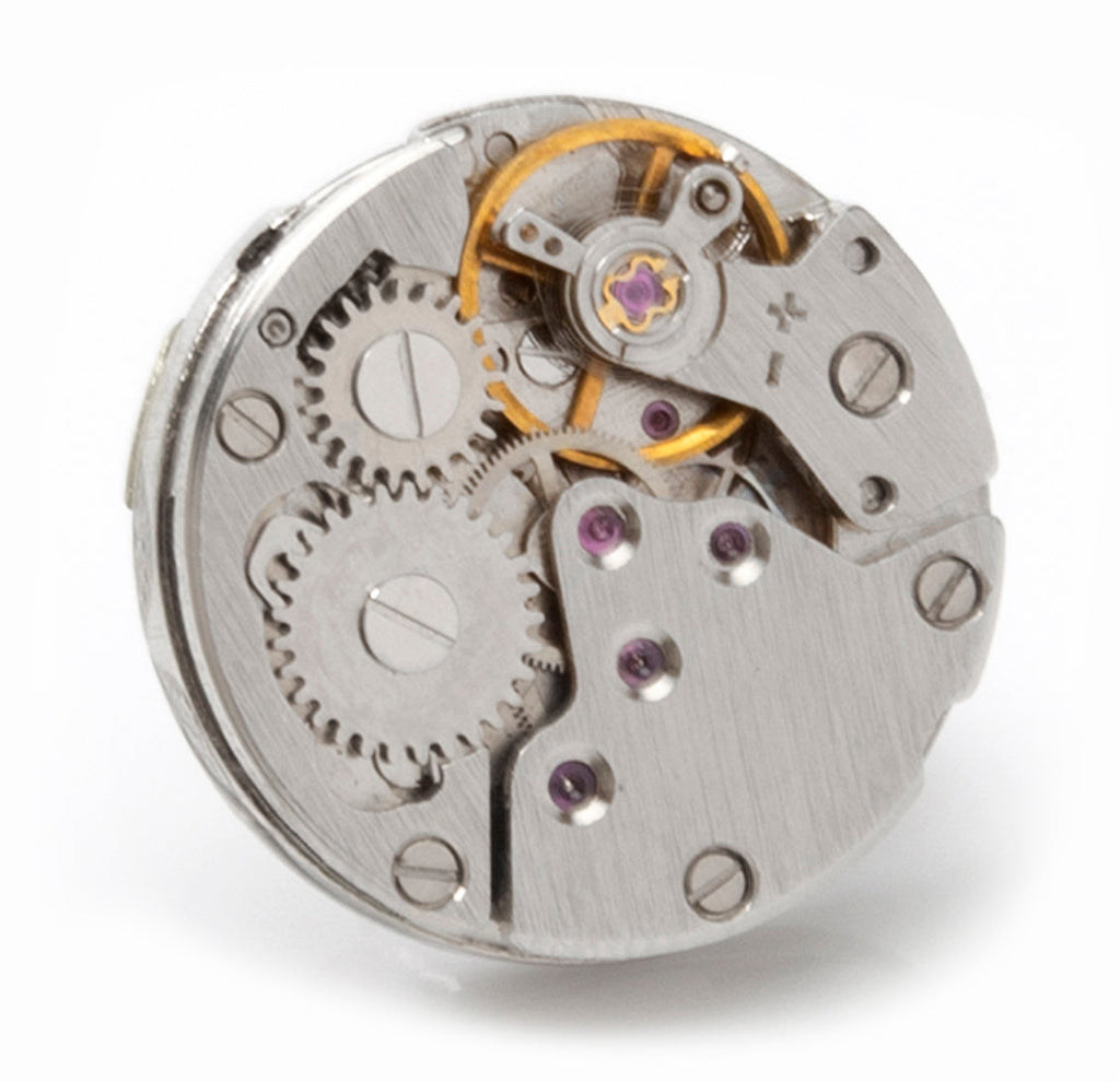 Silver circular skeleton watch-movement lapel pin with purple jeweled screws