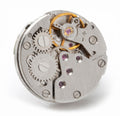Silver circular skeleton watch-movement lapel pin with purple jeweled screws