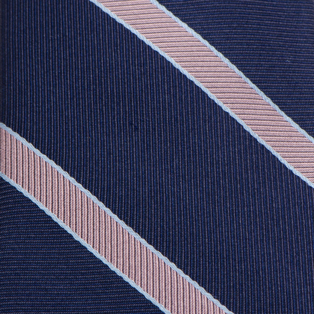 Close-up of navy necktie fabric with light pink diagonal pinstripes