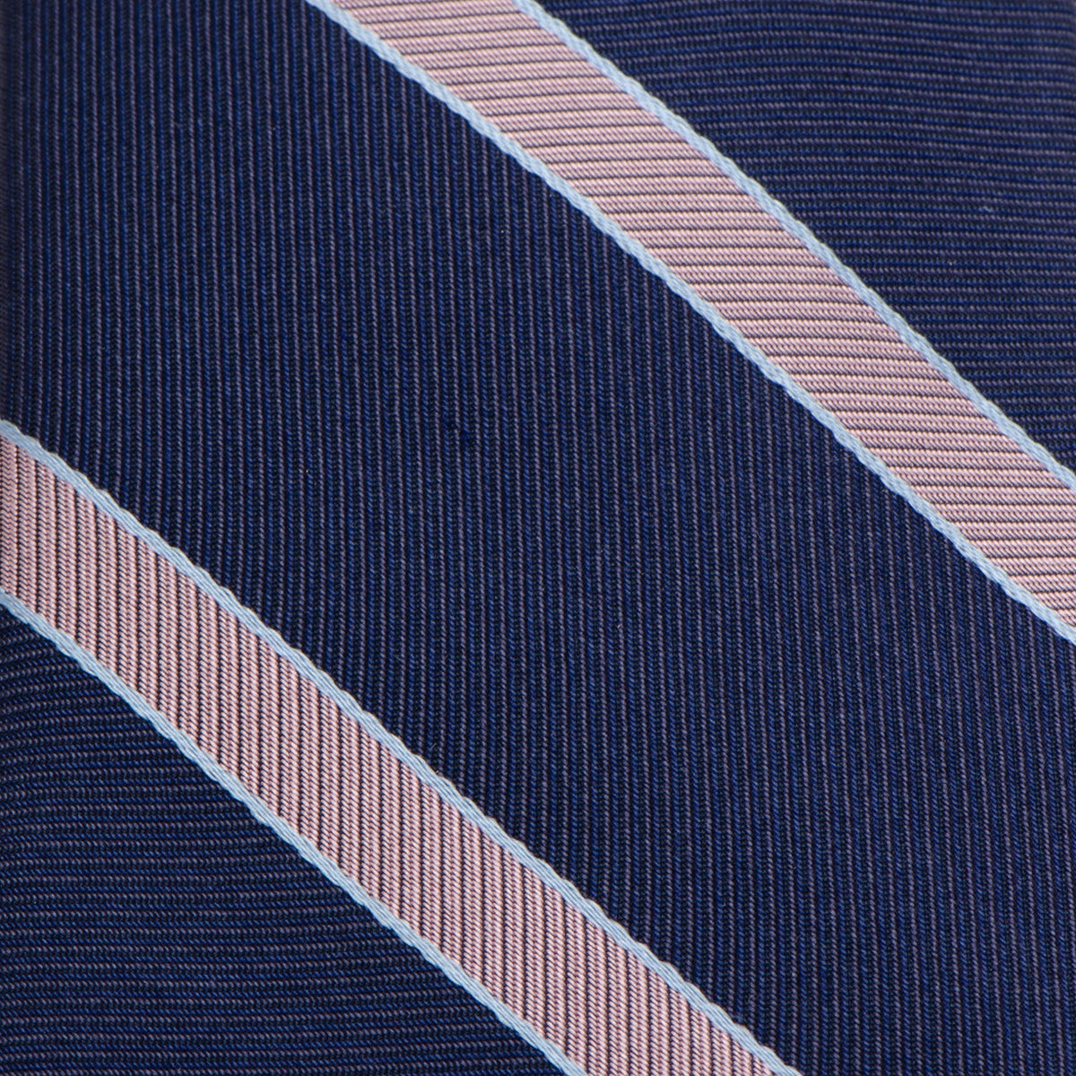 Close-up of navy necktie fabric with light pink diagonal pinstripes