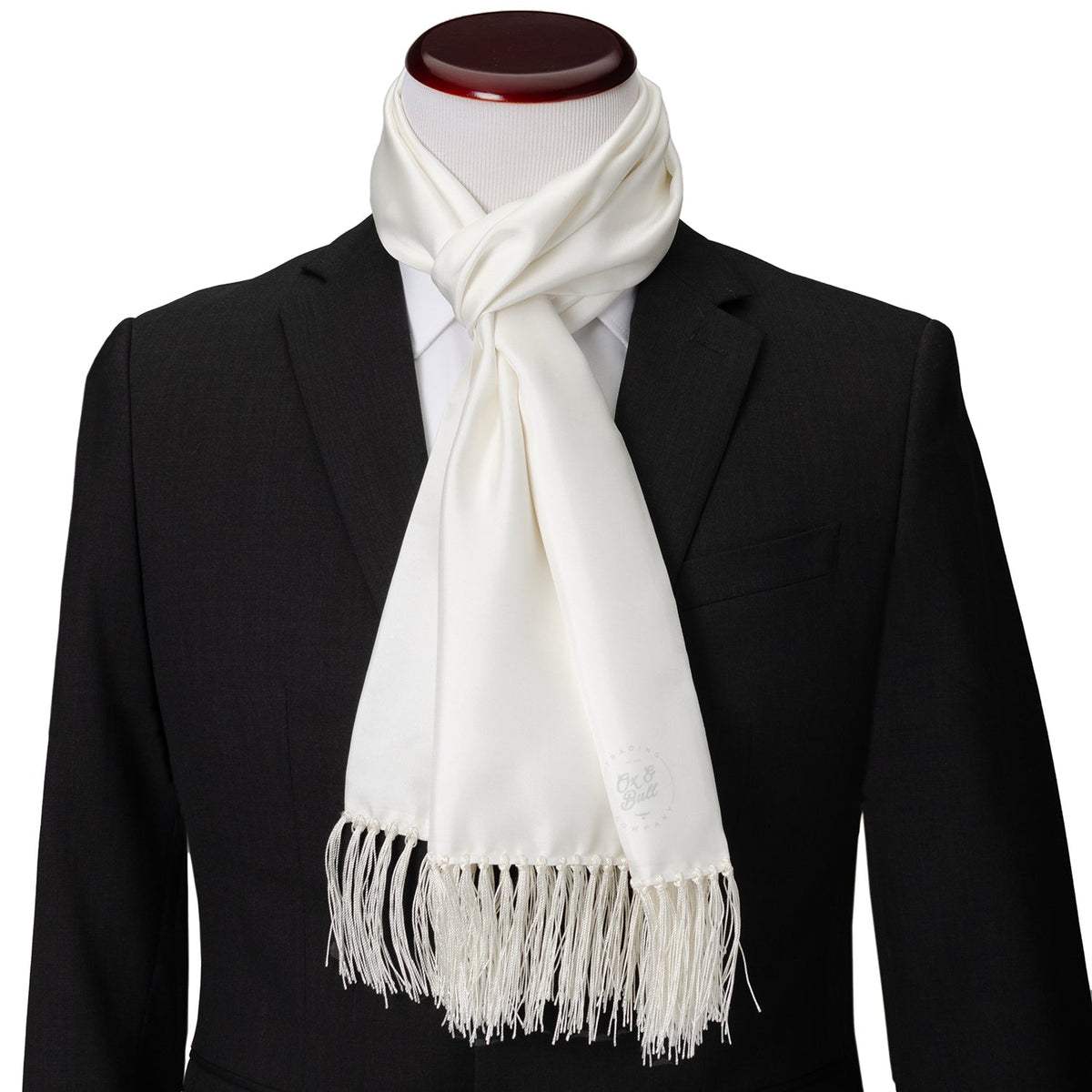 White silk tuxedo scarf with fringed hem, styled on a suit
