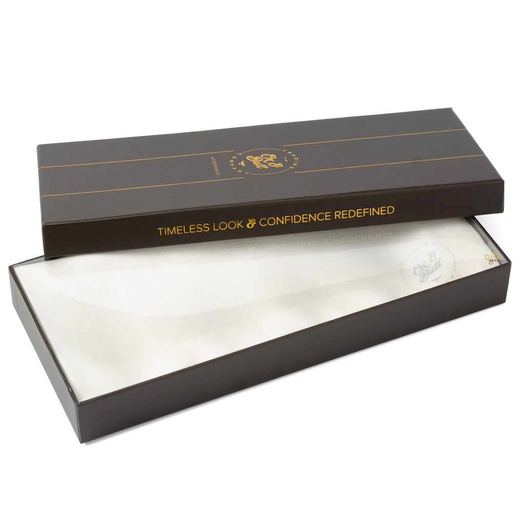 White silk tuxedo scarf inside open gift box, satin fabric visible