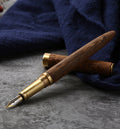 Handmade wood fountain pen with gold-toned body and silver inlay nib