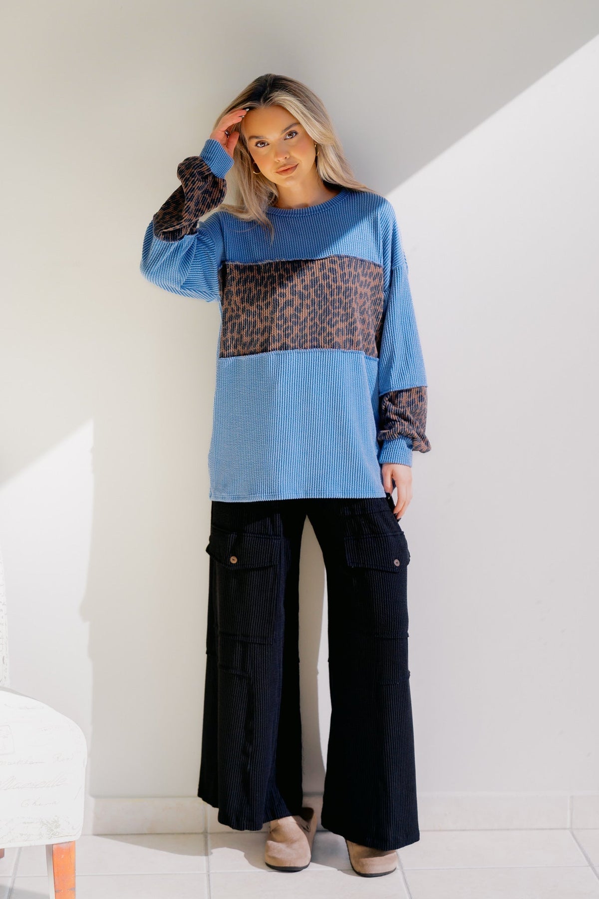 Blue knit sweater with leopard-print panel; ribbed neckline and cuffs