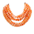 Coral orange multi-strand beaded statement necklace with layered round beads.