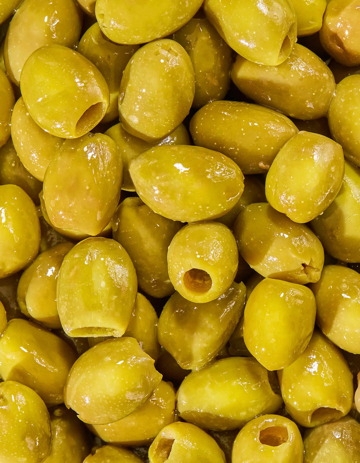 Green olive halves in a pile