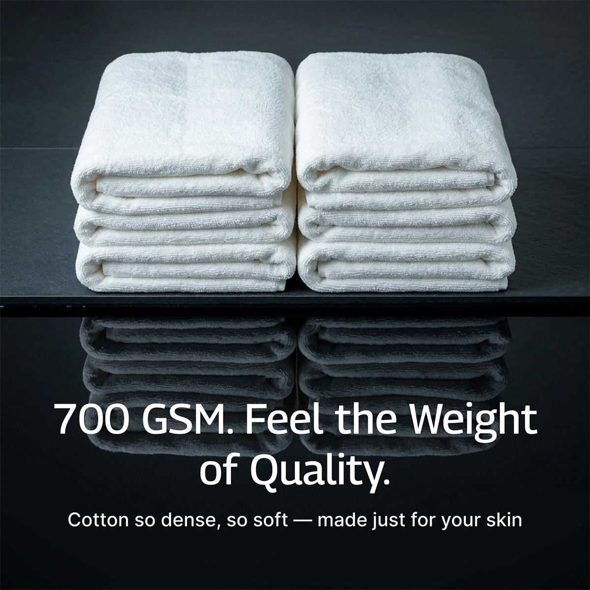 Two stacks of white bath towels, neatly folded with plush ribbed layers
