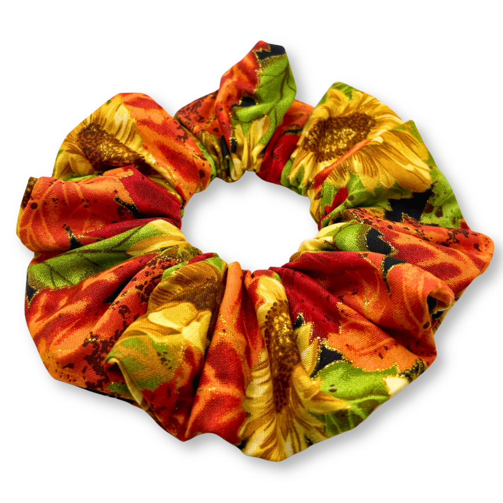 Sunflower print fabric scrunchie in orange, red, and green, gathered swirl design