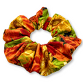 Sunflower print fabric scrunchie in orange, red, and green, gathered swirl design
