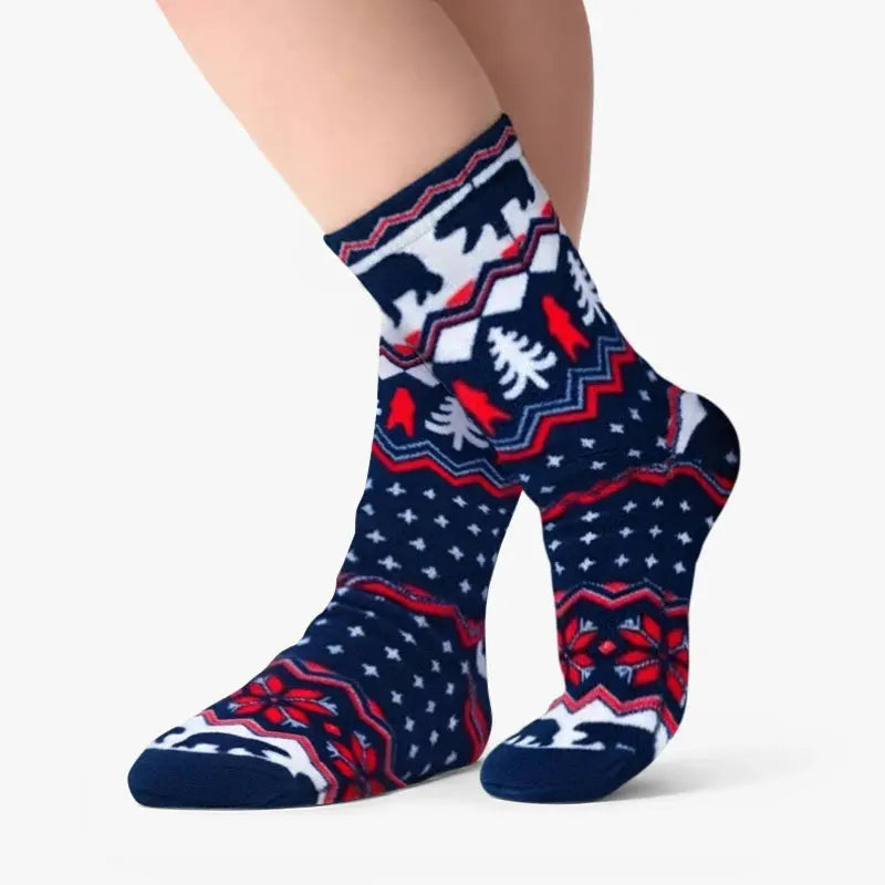 Crew socks on a leg, navy with polar bear and tree Fair Isle pattern in red