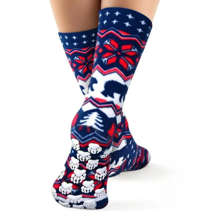 Fleece crew socks on a leg, navy with polar bear, trees, and red geometric pattern