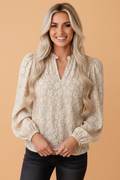 Apricot floral textured long-sleeve blouse with V-neck, puff sleeves, gathered cuffs