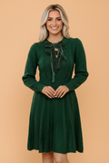 Dark green cable-knit mini sweater dress with bow-tie neckline and long sleeves.