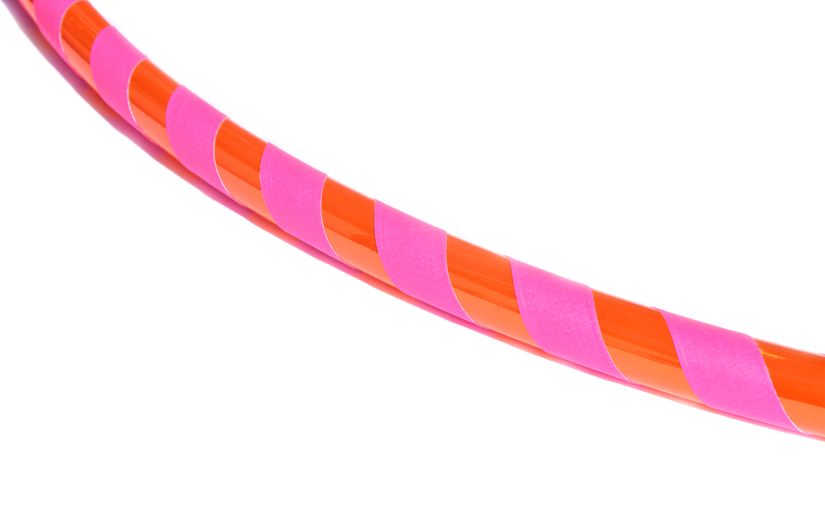Orange and pink hula hoop with neon tape bands wrapped around the tube